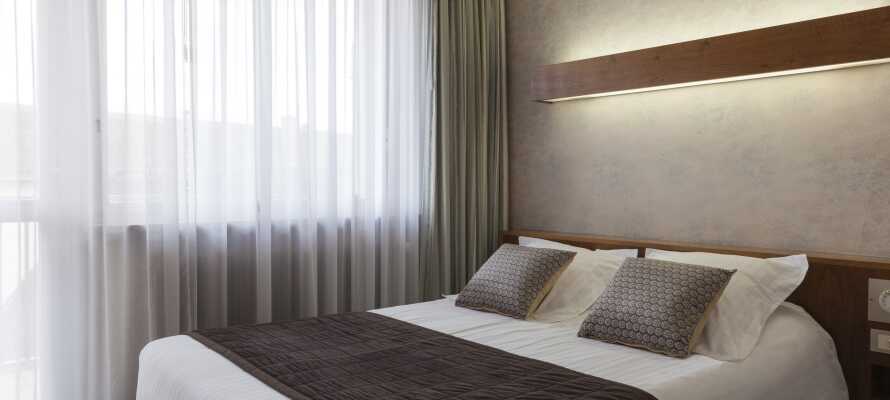 Hotellets flotte og komfortable værelser er indrettet i bløde farver med træpaneler og stilfulde møbler. 